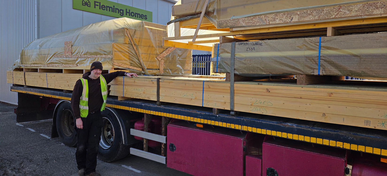 Timber frame materials loaded onto a lorry outside the Fleming Homes workshop
