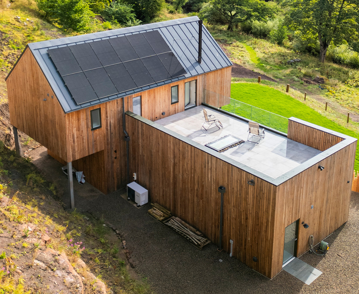 Rear view of The Quarry home with solar panels and roof terrace