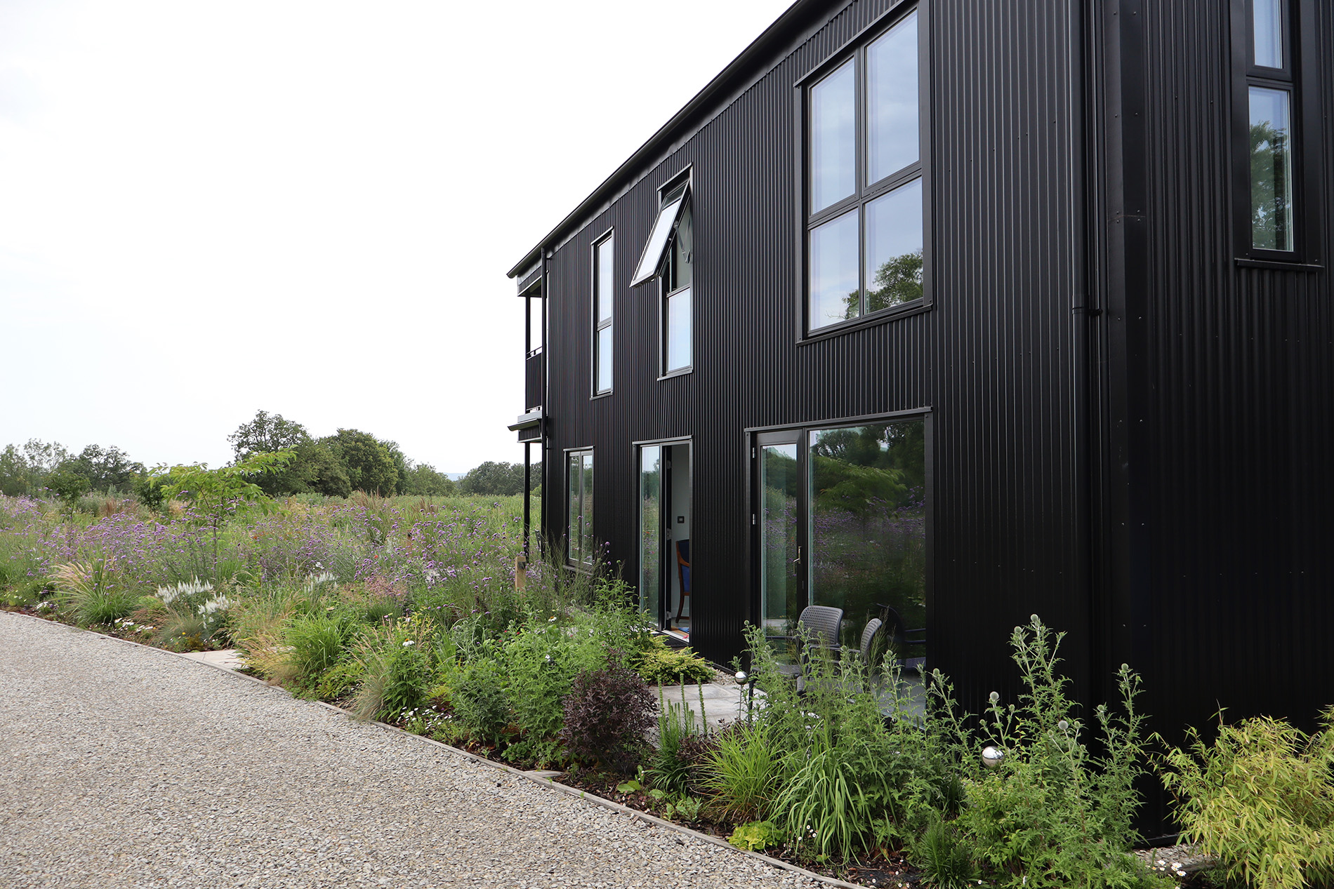 Front aerial view of a completed black modern barn-style timber frame self-build home in Kent.